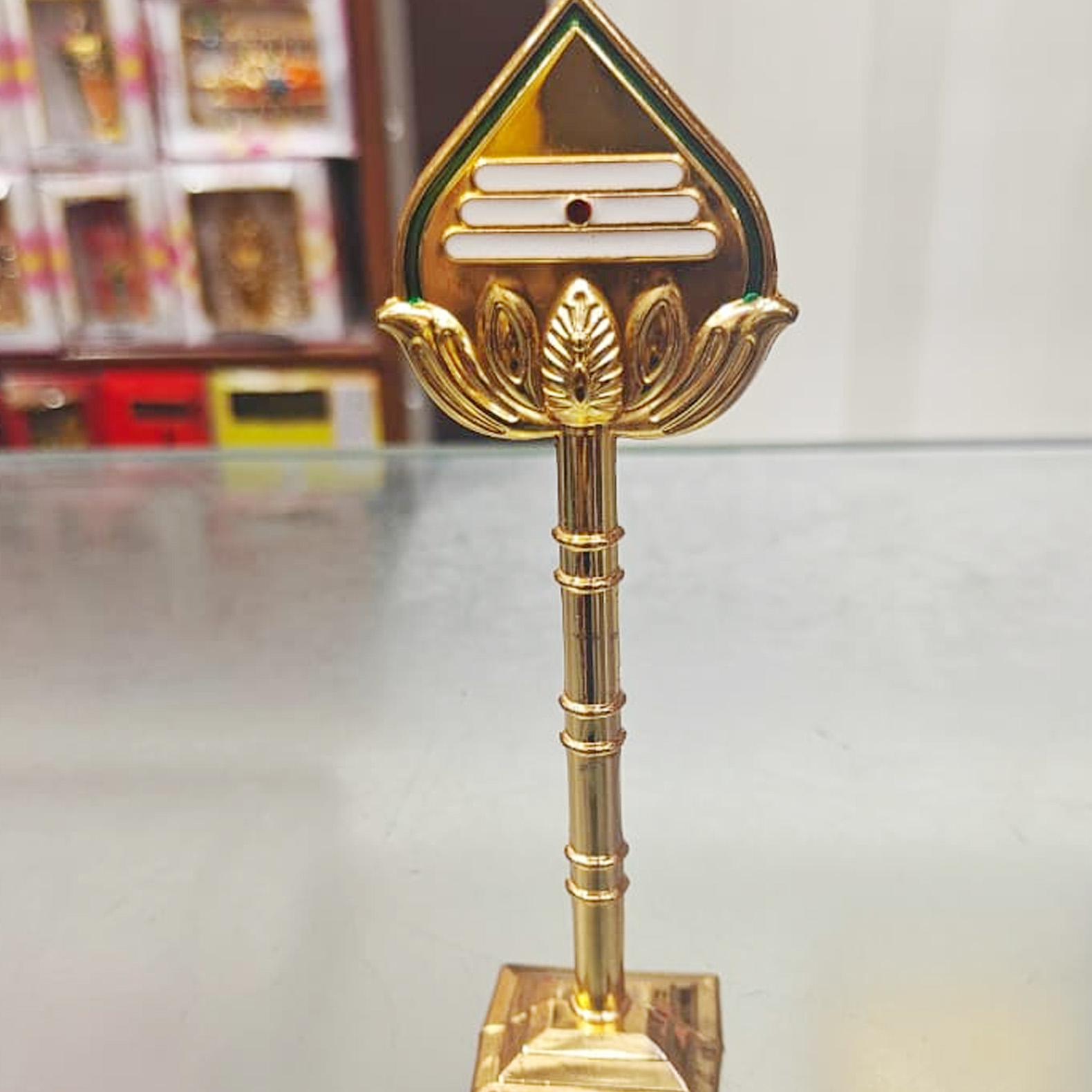 Golden Lord Murugan Vel on a display stand